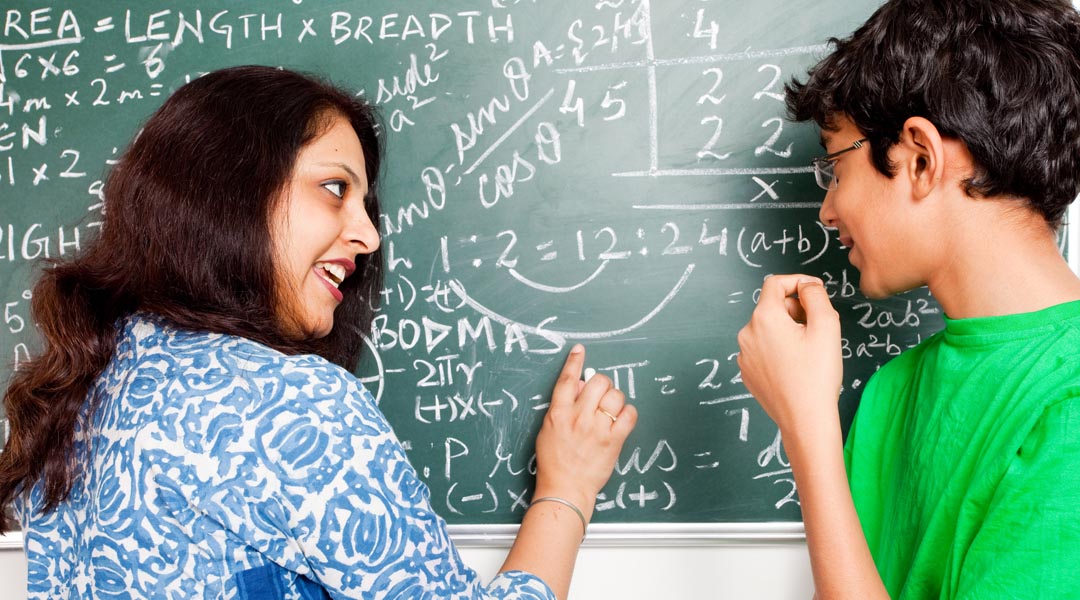 Young Indian Teacher explaining Mathematics problems to her student.